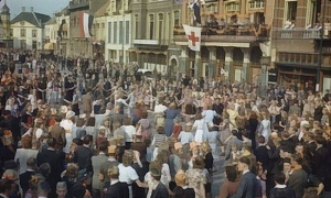 Children wearing orange ribbons and waving Dutch flags