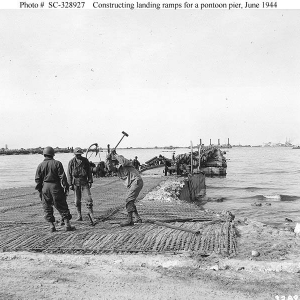 U.S. Soldiers construct a landing ramp as part of the Mulberry "A" artificial harbor at "Omaha" Beach.